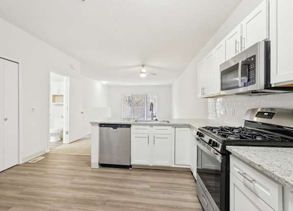 A kitchen with white cabinets and a black stove top oven.