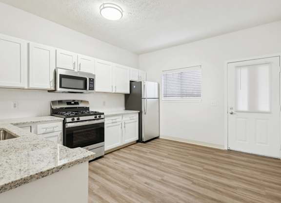 A kitchen with white cabinets and a black stove top oven.
