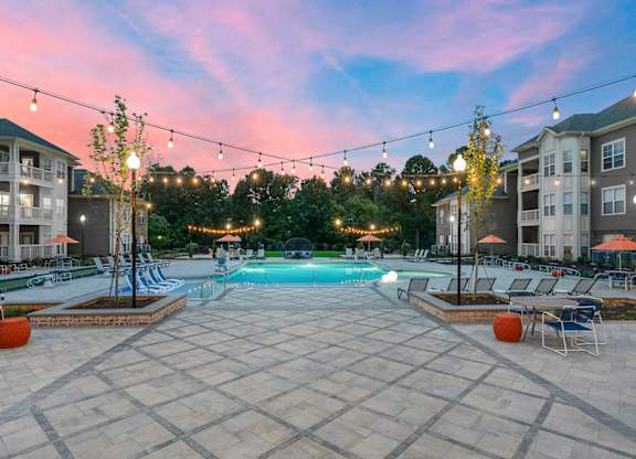 Saltwater pool with outdoor entertaining areas with bistro string lights during sunset