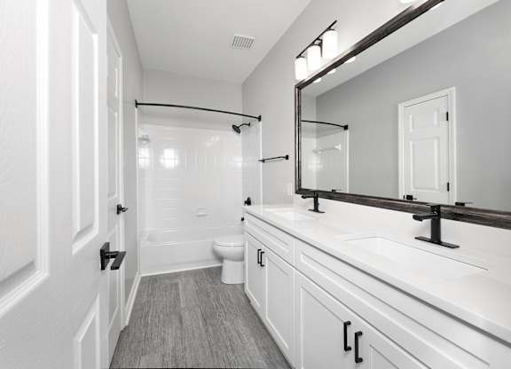 Bathrooms with double vanity sinks, garden soaking tubs and curved shower rods