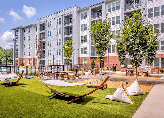 Outdoor entertaining area with hammocks, cornhole, firepit and grills