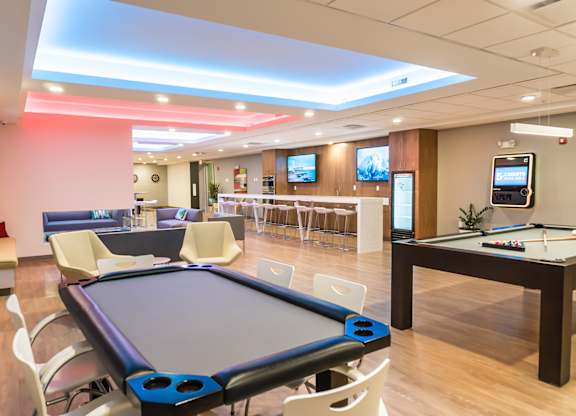 Gaming lounge with poker table, billiards, shuffleboard, darts and fireplace