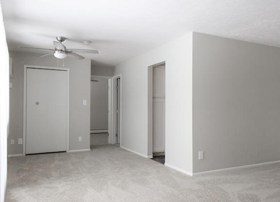 Living room with plush carpet and ceiling fan