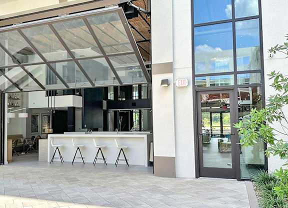 Impressive multi-story clubhouse with glass garage-style doors that open to outside