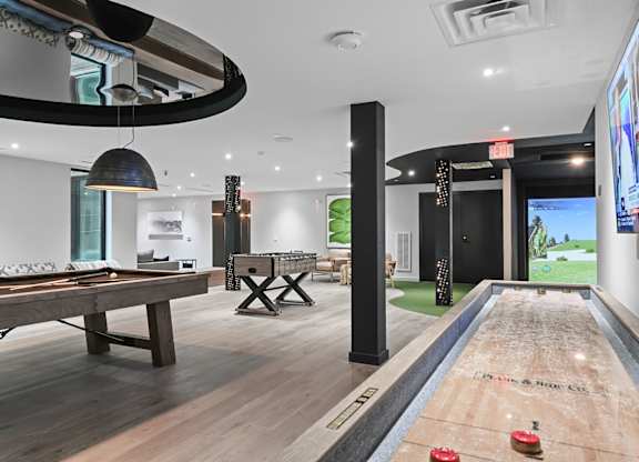 Pool table, shuffleboard, and virtual golf in gaming lounge