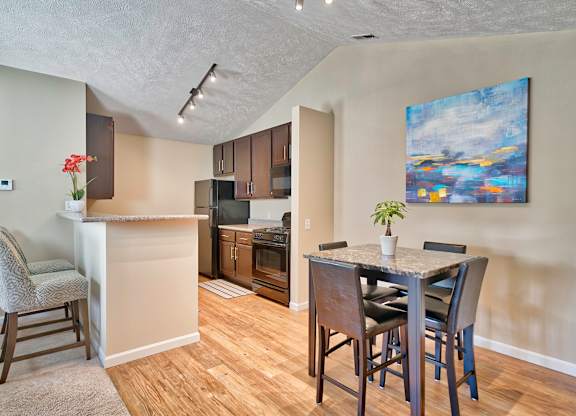Kitchen with hardwood-inspired flooring and vaulted ceilings in select suites