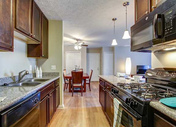 Renovated units with granite countertops and hardwood-inspired flooring in kitchens