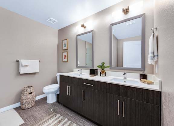 Large bathrooms with dual vanities and framed mirrors