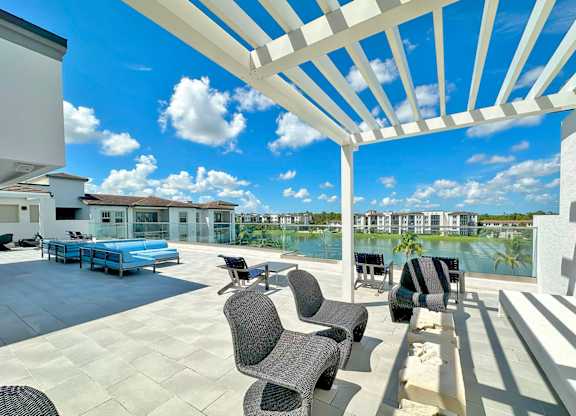 Partially shaded rooftop terrace with TVs, kitchen and bar