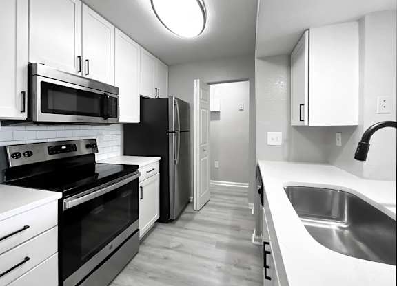 Renovated kitchen with quartz counters and matte black hardware at Cypress Grand