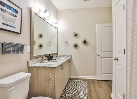 Dual vanities with granite countertops and framed mirrors