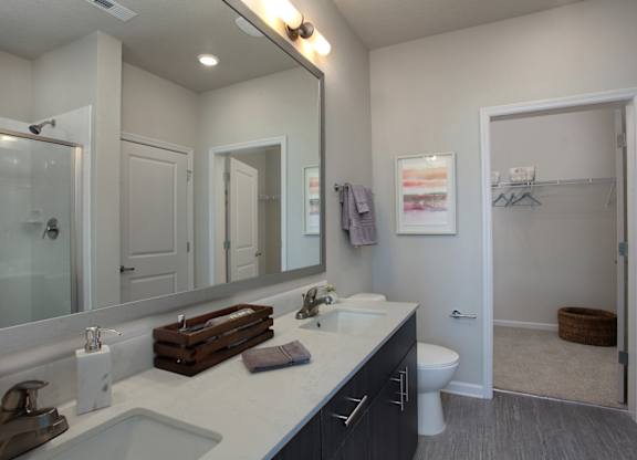 Bathrooms with quartz countertops, dual vanities and framed mirrors