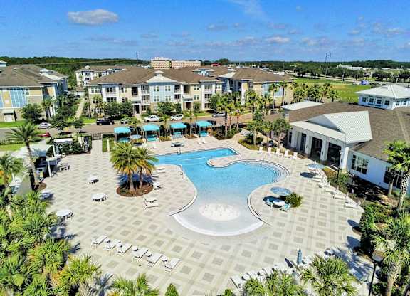 Beach-entry pool with splash pad, volleyball net, swim lane and cabanas