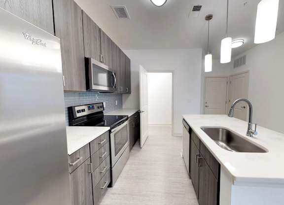 Chef's kitchens feature islands with quartz countertops, undermount sinks, stainless steel appliances