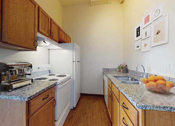 A kitchen with a white fridge and wooden cabinets.