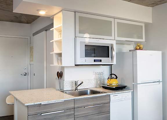 A modern kitchen with a white refrigerator, microwave, and stove.