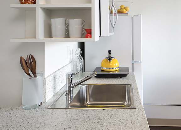 A kitchen with a sink and a refrigerator.