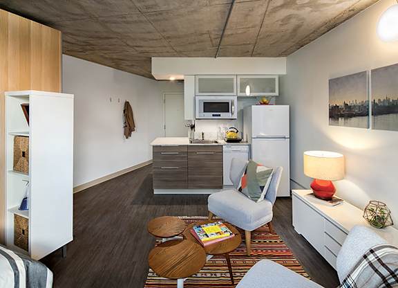 A modern kitchen with a refrigerator, microwave, and oven.