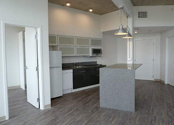 A kitchen with a black countertop and white cabinets.