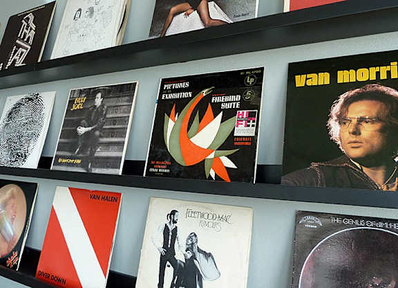 A wall of posters including one for Pink Floyd.