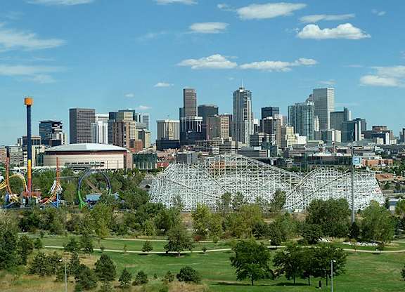 A city skyline with a large amusement park in the foreground.
