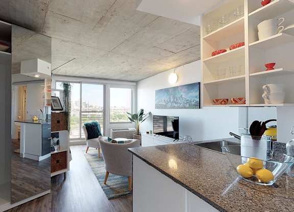 A kitchen with a counter top and a bowl of lemons on it.
