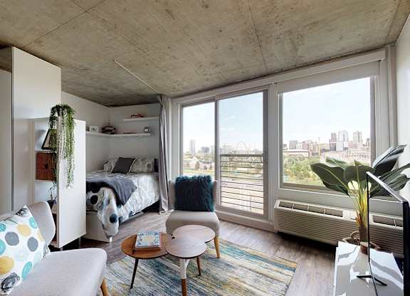 A bedroom with a bed, a chair, and a table.