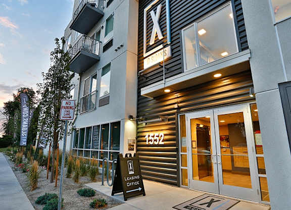 A modern building with a leasing office and a no parking sign.