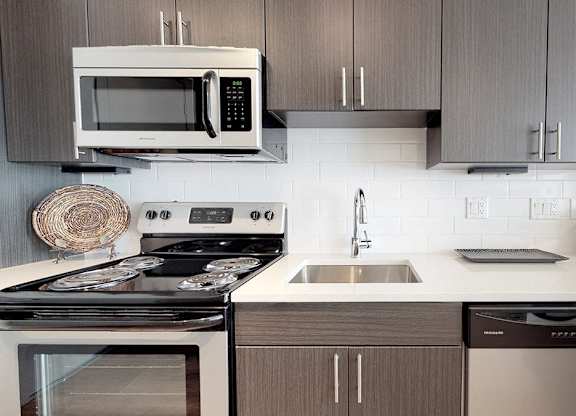A modern kitchen with a stove, microwave, and dishwasher.