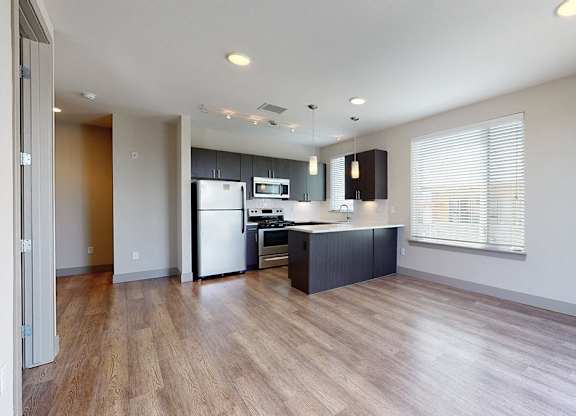 A kitchen with a refrigerator, microwave, and oven.