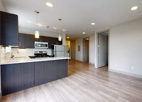 A modern kitchen with dark wood cabinets and a white countertop.