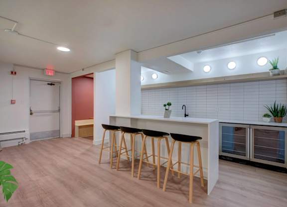 A community kitchen area with a bar and stools.