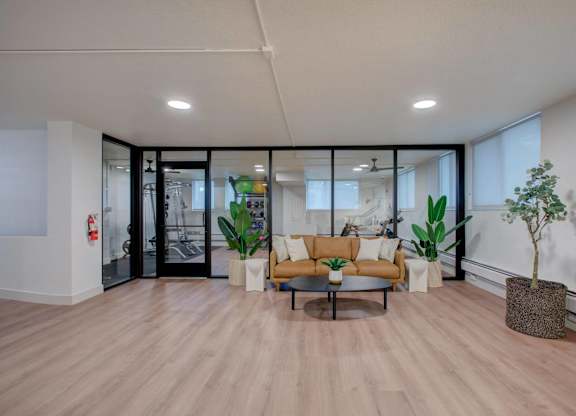 A modern living room with a wooden floor and a glass door leading to a balcony.