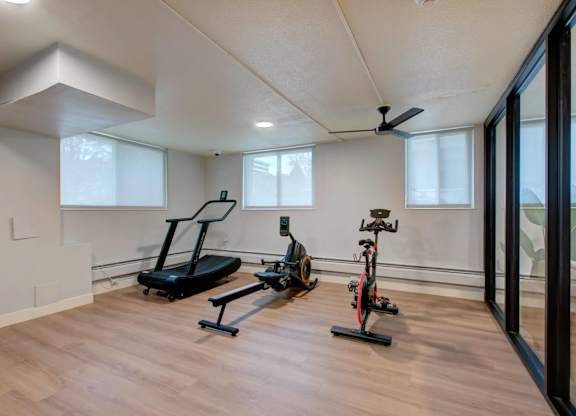 A room with a treadmill and a stationary bike.