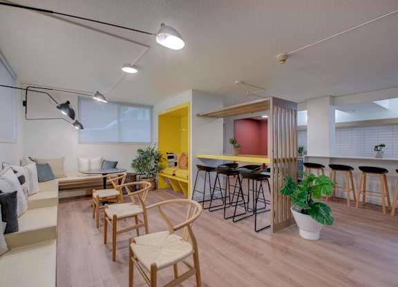 A community room with multiple seating options, including bar seating, nooks, and regular chairs.
