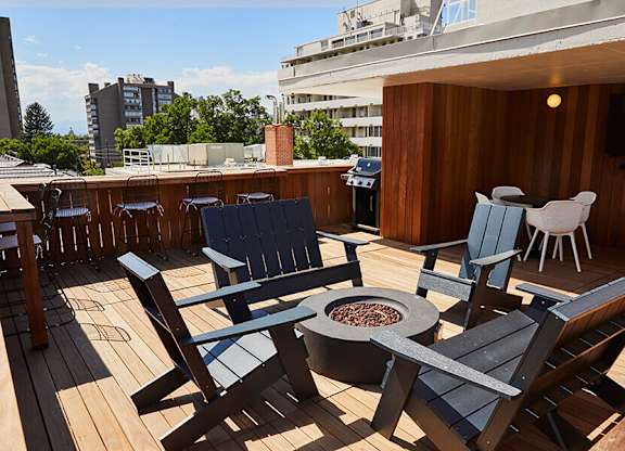 A wooden deck with chairs and a fire pit.