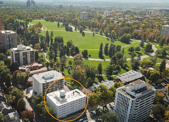 An aerial view of a city with a large white building circled in the middle.