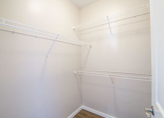 A white closet with shelves and a door.