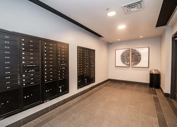 A hallway with a row of mailboxes on the wall.