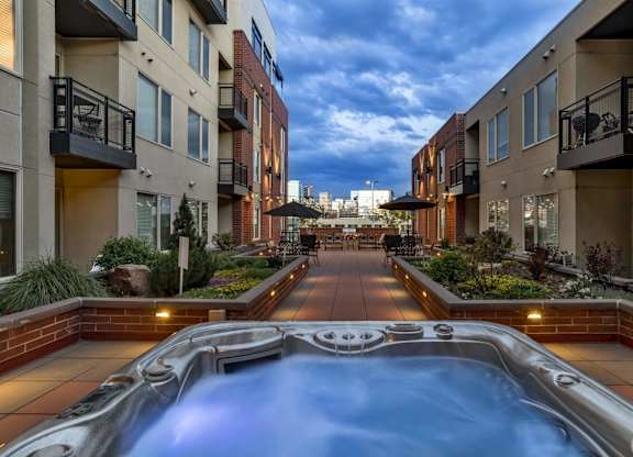 A hot tub in the middle of a courtyard surrounded by buildings.