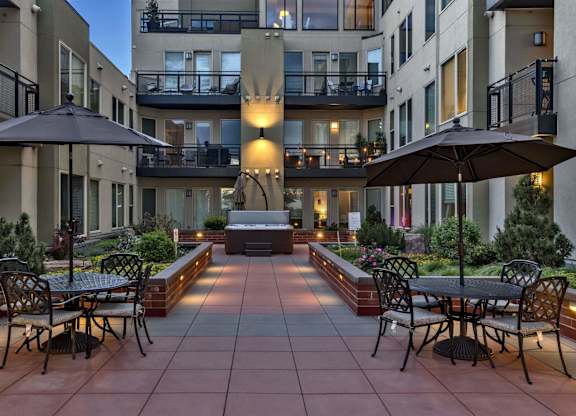 A courtyard with tables and chairs surrounded by buildings.