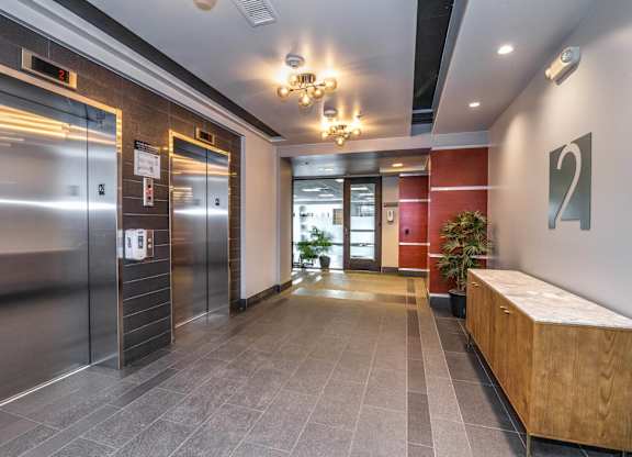 A hallway with a wooden bench and a chandelier.
