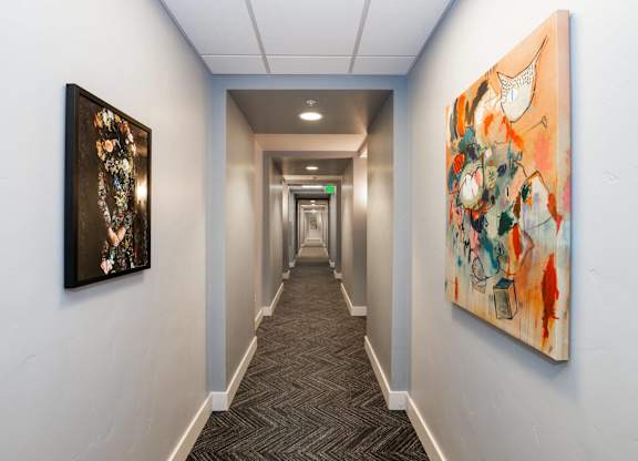 A hallway with two paintings on the wall.