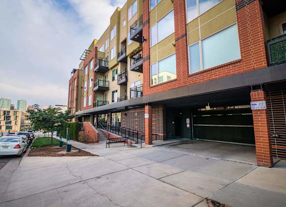 A multi-story building with a parking lot in front.
