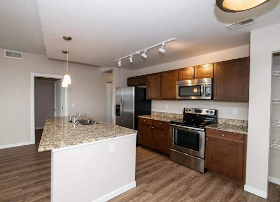 A kitchen with wooden cabinets and a granite countertop.