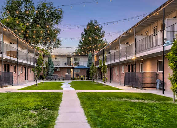 A courtyard surrounded by apartment buildings with a walkway in the middle.