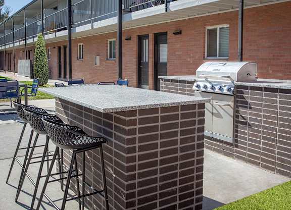 A brick patio with a bar and stools.