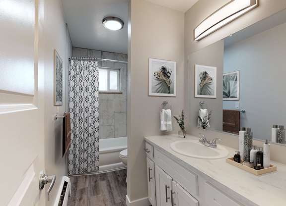 A bathroom with a white sink and a shower with a glass door.