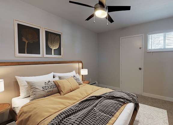 A bedroom with a bed, a ceiling fan, and a window.