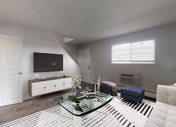 A modern living room with a glass coffee table and a television.